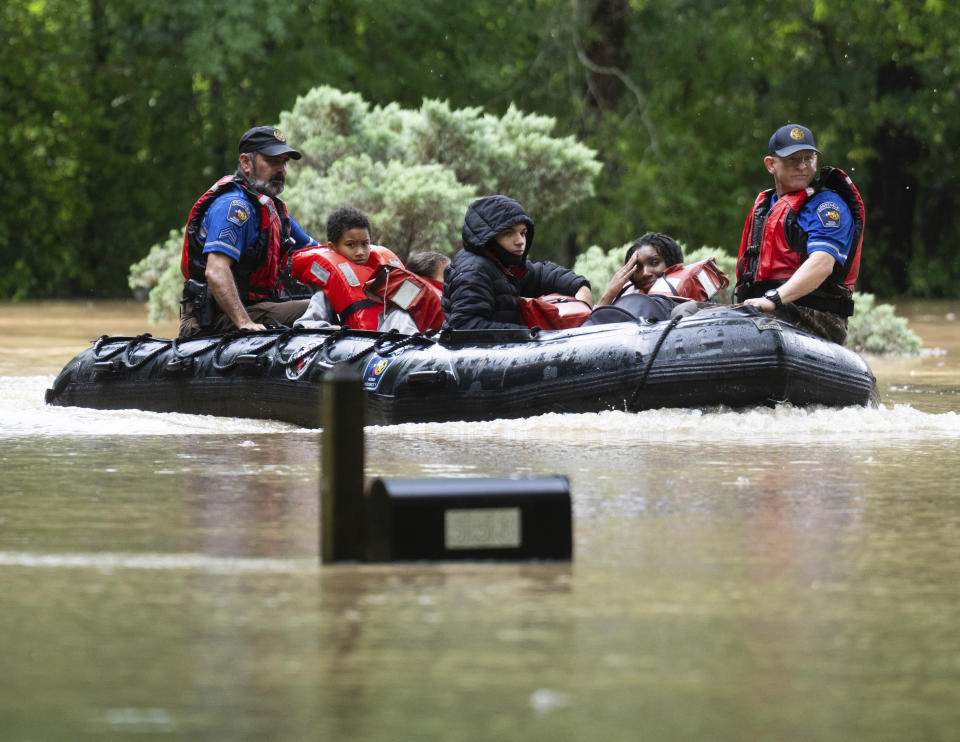 A woman reacts as she and others are evacuated by boat from their homes by Montgomery County Sheriff's Office deputies, Friday, May 3, 2024, in Conroe, Texas. Torrential rain is inundating southeastern Texas, forcing schools to cancel classes and closing numerous highways around Houston. (Jason Fochtman/Houston Chronicle via AP)