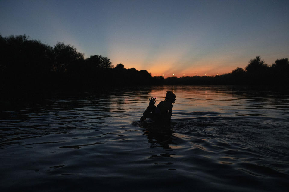 Haitian migrants wade across the Rio Grande from Del Rio, Texas, to return to Ciudad Acuña, Mexico, Sunday, Sept. 19, 2021, to avoid deportation to Haiti from the U.S. The U.S. is flying Haitians camped in a Texas border town back to their homeland and blocking others from crossing the border from Mexico in a massive show of force that signals the beginning of what could be one of America's swiftest, large-scale expulsions of migrants or refugees in decades. (AP Photo/Felix Marquez)