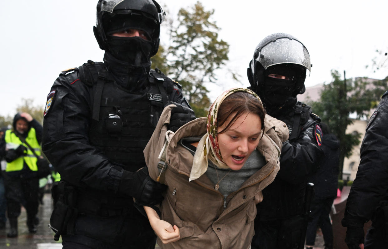 Police officers detain a woman during a protest in Moscow (AFP via Getty Images)