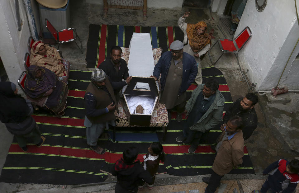 Family members take the last look of Rasheeda Bibi, who was killed in the suicide bombing, before her funeral in Peshawar, Pakistan, Tuesday, Jan. 31, 2023. The death toll from the previous day's suicide bombing at a mosque in northwestern Pakistani rose to more than 85 on Tuesday, officials said. The assault on a Sunni Mosque inside a major police facility was one of the deadliest attacks on Pakistani security forces in recent years. (AP Photo/Muhammad Sajjad)