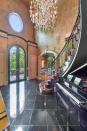 The entryway of the nearly 7,000-square-foot home opens into a sweeping staircase. (Photo credit: Josh Vick, HomeTour America)