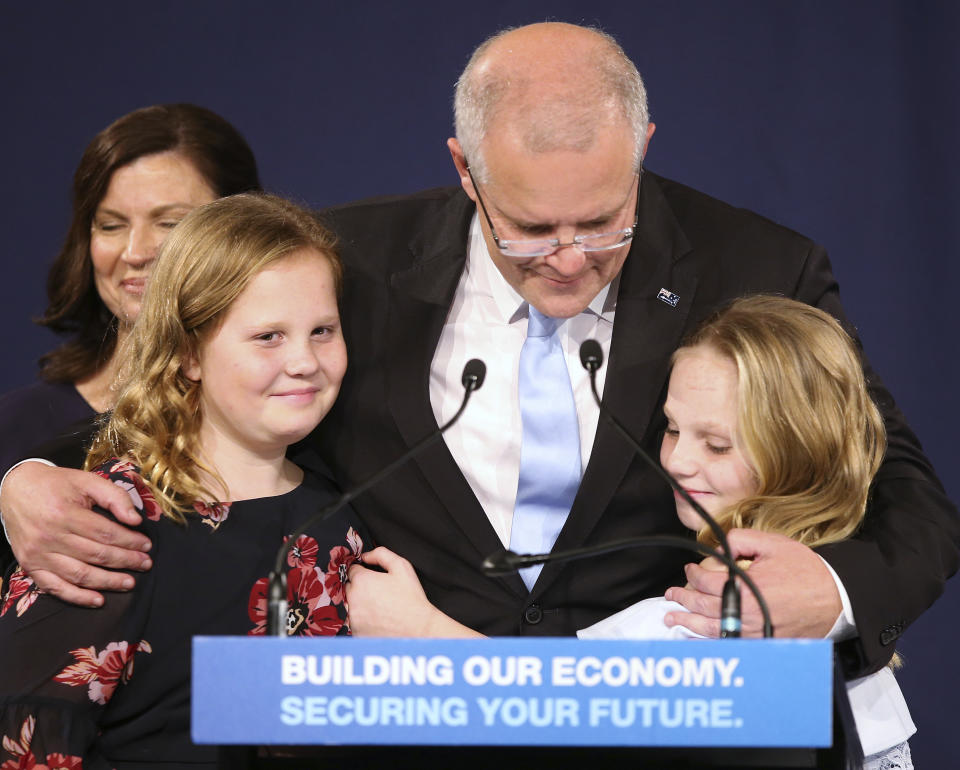 Australian Prime Minister Scott Morrison, center, embraces his daughters Lily, right, and Abbey, after his opponent concedes defeat in the federal election in Sydney, Australia, Sunday, May 19, 2019. Australia's ruling conservative coalition, lead by Morrison, won a surprise victory in the country's general election, defying opinion polls that had tipped the center-left opposition party to oust it from power and promising an end to the revolving door of national leaders. (AP Photo/Rick Rycroft)