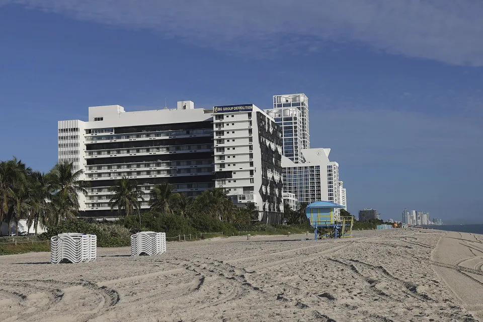 The historic Deauville Beach Resort is shown, Sunday, Nov. 13, 2022, moments before imploding in Miami, Beach, Fla. The once-luxurious hotel that hosted the Beatles and President John F. Kennedy during its 1960s heyday has been imploded. The 17-story Deauville Hotel fell into itself Sunday after a series of explosions were set off, sending up a large cloud of dust. (Carl Juste/Miami Herald via AP)