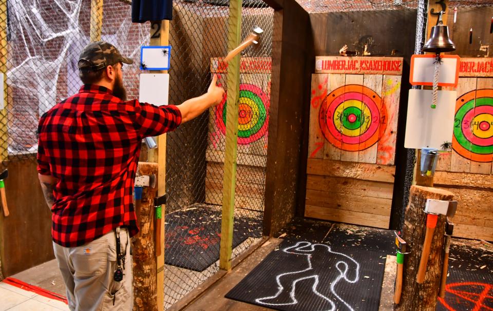 Manager Jay Herzner throws an axe at a target inside Lumber Jack's Axe House in downtown Melbourne.