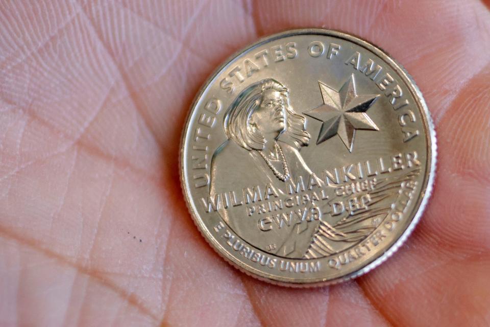 A woman shows her new Wilma Mankiller quarter after purchasing it Monday after a ceremony celebrating the release of the quarter  in Tahlequah.