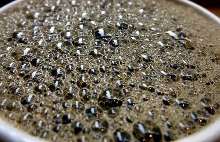 Bubbles form on the surface of a cup of coffee in a cafe in New York, April 11, 2014. REUTERS/Carlo Allegri/File Photo