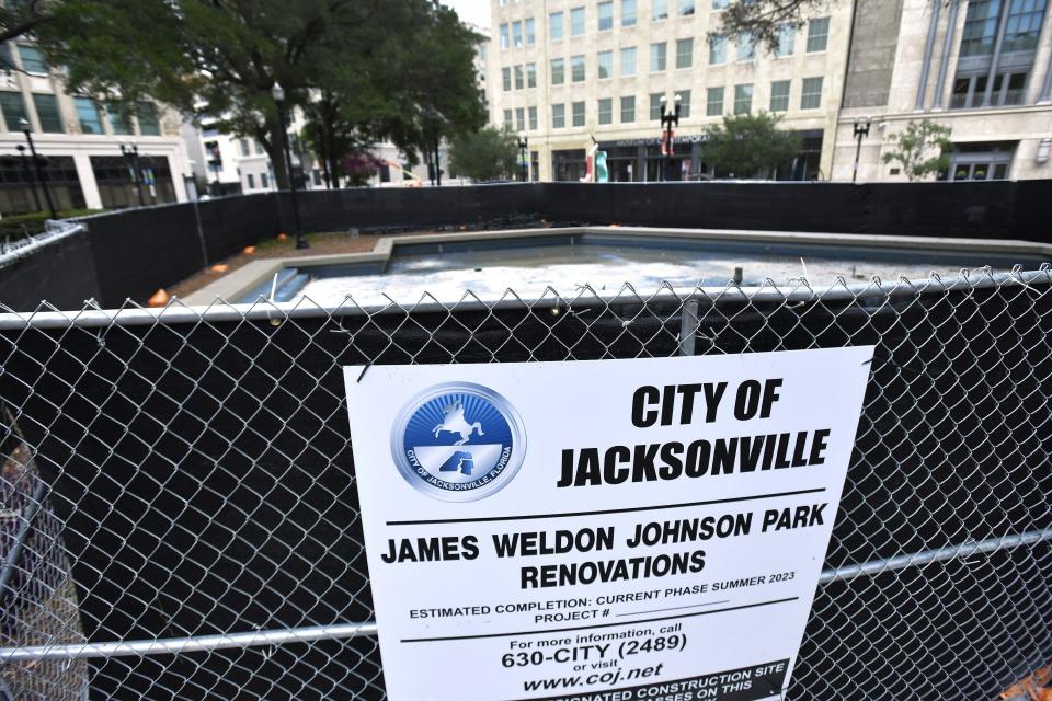 A sign on the construction fence at the fountain next to Laura Street announcing renovations to James Weldon Johnson Park.