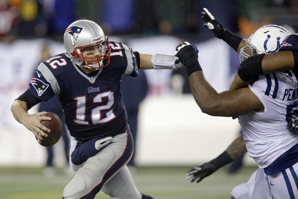 New England Patriots quarterback Tom Brady (12) scrambles away from Indianapolis Colts defensive tackle Jeris Pendleton, right, during the second half of an AFC divisional NFL playoff football game against the Indianapolis Colts in Foxborough, Mass., Saturday, Jan. 11, 2014. (AP Photo/Stephan Savoia)