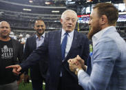 Dallas Cowboys owner Jerry Jones, second from right, and UFC fighter Conor McGregor, right, stand on the sideline before an NFL football game against the Jacksonville Jaguars in Arlington, Texas, Sunday, Oct. 14, 2018. (AP Photo/Jim Cowsert)