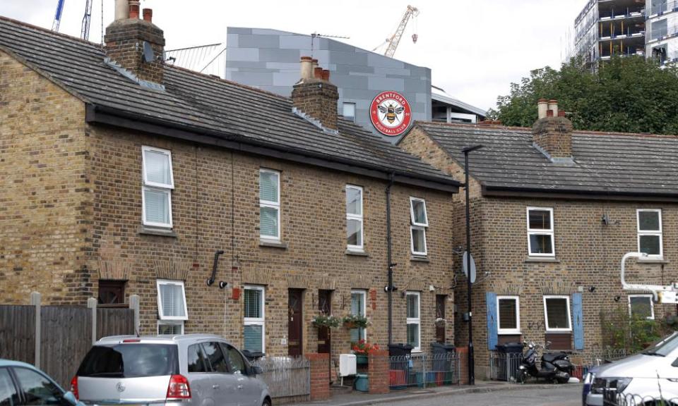 The Brentford Community Stadium rising up from behind terraced housing.