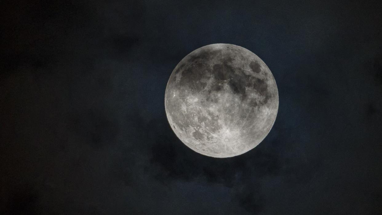  A bright full moon grows dark as it drifts into Earth's shadow during a penumbral lunar eclipse 