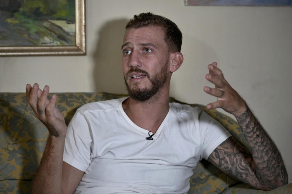 Jihad Michlawi, 31, speaks during an interview with The Associated Press at his home in the northern Beirut suburb of Burj Hammoud, Lebanon, Tuesday, Sept. 27, 2022. Michlawi is one of dozens of survivors from a migrant boat that left Tripoli, Lebanon heading towards Italy carrying over 100 Lebanese, Syrians, and Palestinians, that capsized near the Syrian coastal city of Tartus. At least 94 people were killed. (AP Photo/Bilal Hussein)