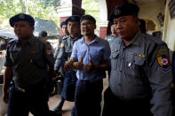 Detained Reuters journalist Wa Lone is escorted by police, during a court hearing break in Yangon, Myanmar May 22, 2018. REUTERS/Ann Wang