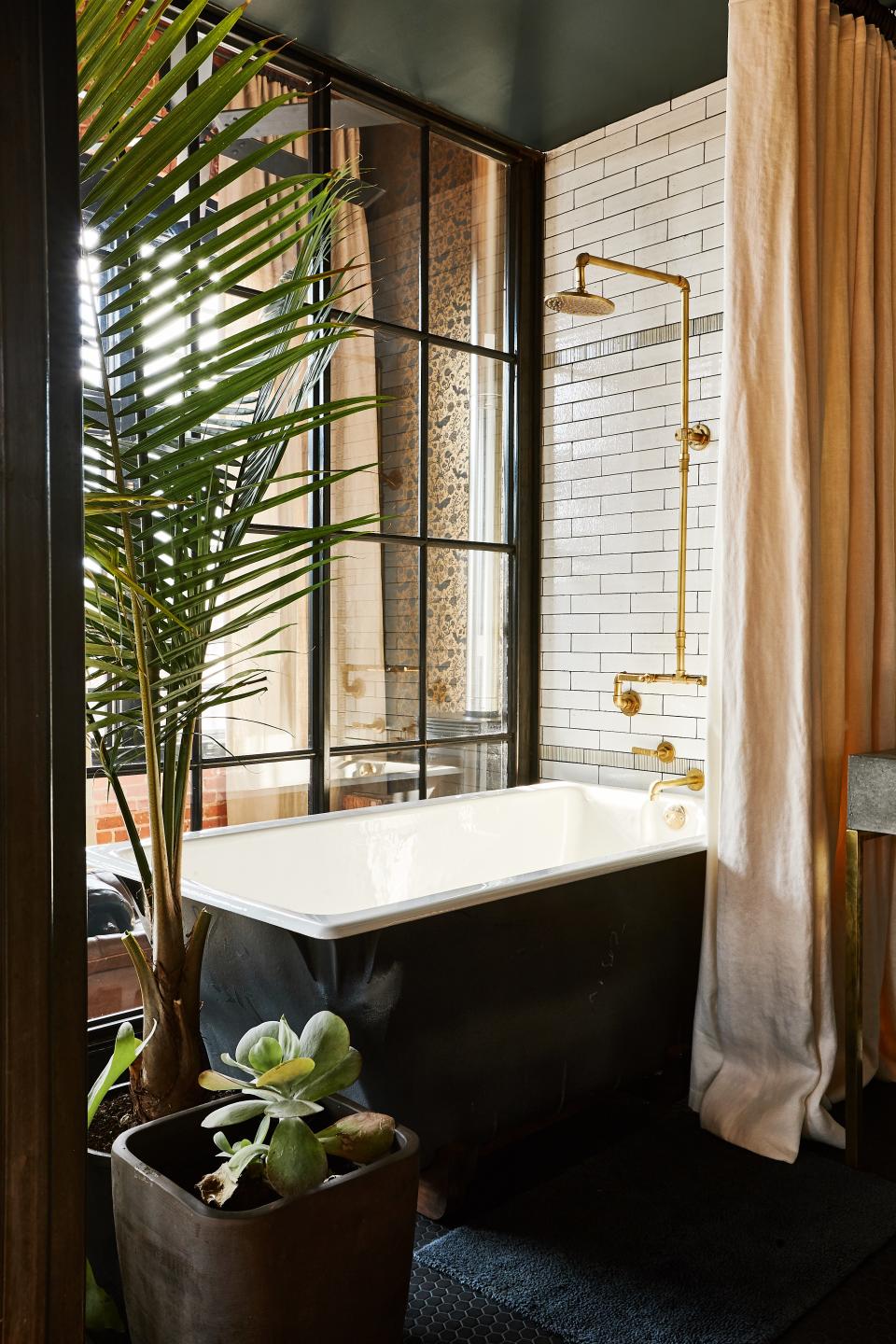 "I started really responding to the idea of having a bathroom that was basically a glass box, and it's truly a remarkable piece of craftsmanship," says Brown. The shower wall tiles are from Ann Sacks Savoy Collection; the tub is Kohler's "Tea for 2."
