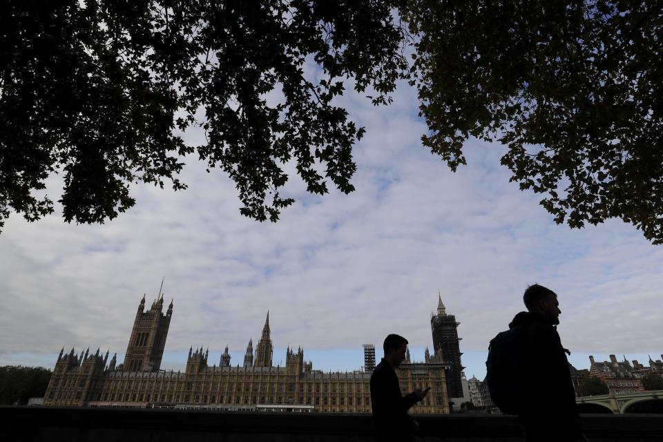 People walk opposite Britain's Parliament in London, Friday, Oct. 16, 2020. Britain’s foreign minister says there are only narrow differences remaining in trade talks between the U.K. and the European Union. But Dominic Raab insists the bloc must show more “flexibility” if it wants to make a deal. (AP Photo/Kirsty Wigglesworth)