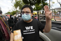 Pro-democracy activist Parit "Penguin" Chiwarak raises a three-finger salute, a symbol of resistance, during a demonstration in Bangkok, Thailand, Thursday, June 24, 2021. Anti-government protests resumed in Bangkok after a long break due partly to a surge in COVID-19 cases. Gatherings are planned for several locations across the capital, despite health officials mulling a week-long lockdown in Bangkok to control a rampant virus surge. (AP Photo/Sakchai Lalit)