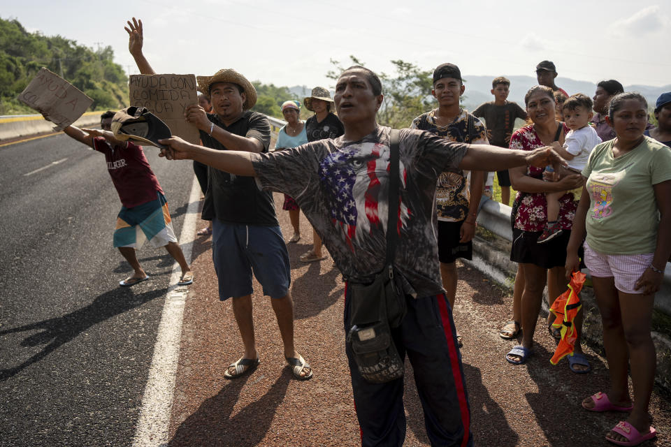 People stand on the side of a road asking for help in the aftermath of Hurricane Otis in Acapulco, Mexico, Friday, Oct. 27, 2023. (AP Photo/Felix Marquez)