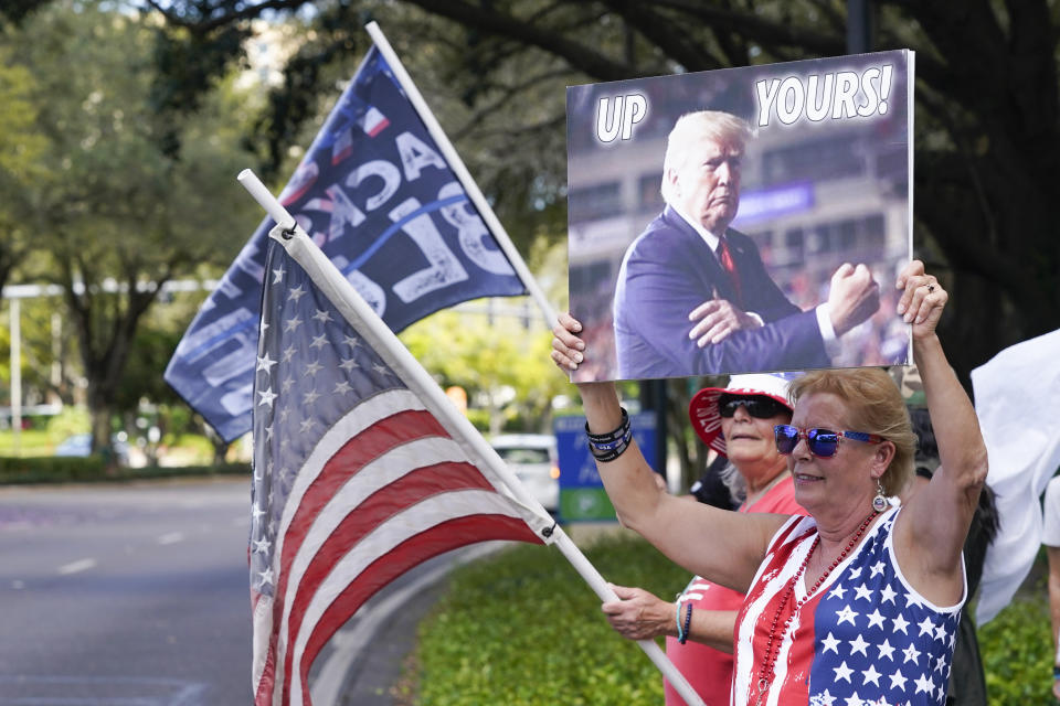 Trump supporters wave flags and signs to motorists driving by the convention center at the Conservative Political Action Conference (CPAC) Saturday, Feb. 27, 2021, in Orlando, Fla. (AP Photo/John Raoux)