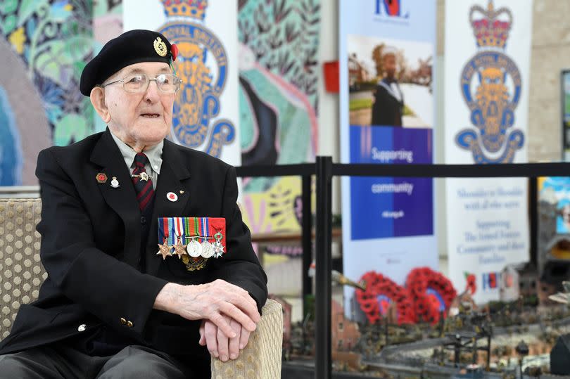 Cpl Pelsar sits in front of the diorama and Royal British Legion display