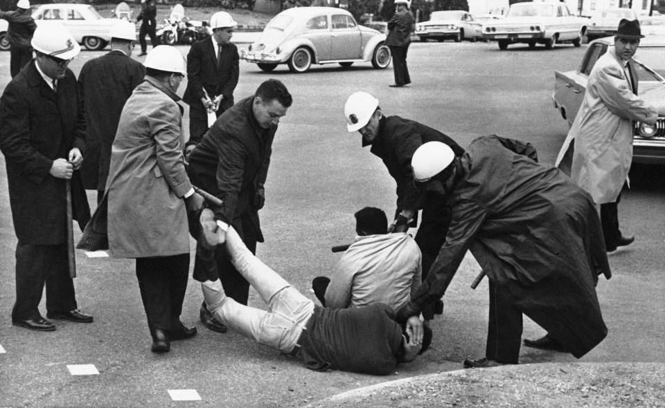 FILE - Police carry off two men who were part of a sit down group at Montgomery, Ala. on March 11, 1965. Hundreds had marched on the Capitol yesterday and several attempted to continue it today. (AP Photo/File)