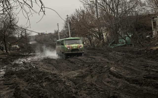 A Ukrainian vehicle drives on a muddy road near Bakhmut in the Donbas region - ARIS MESSINIS/AFP