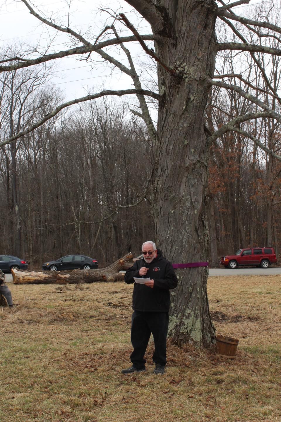 Mark Ware, executive director of the Somerset Historical Center, stands by a generational maple tree during the annual tree tapping ceremony on Saturday as he speaks to the crowd.