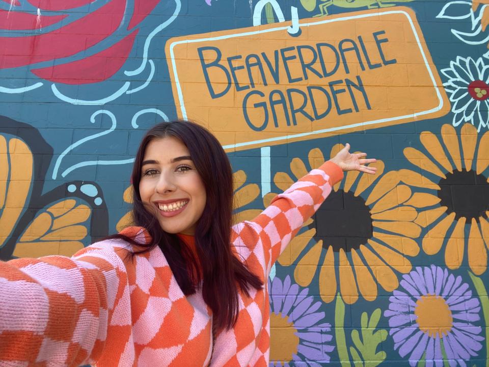 Des Moines Register reporter Paris Barraza takes a selfie in front of a mural near Franklin Barbershop in Des Moines on Sept. 7, 2023.