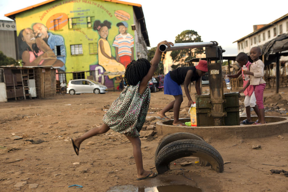 Children fetch water from a borehole in Harare, Zimbabwe, Thursday, April 2, 2020. Zimbabwe went into a lockdown for 21 days in an effort to curb the spread of the coronavirus. The new coronavirus causes mild or moderate symptoms for most people, but for some, especially older adults and people with existing health problems, it can cause more severe illness or death. (AP Photo/Tsvangirayi Mukwazhi)