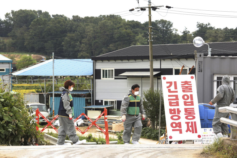 Quarantine officials stand guard as a precaution against African swine fever near a pig farm in Paju, South Korea, Friday, Sept. 20, 2019. South Korea said Friday that it is investigating two more suspected cases of African swine fever from farms near its border with North Korea, as fears grow over the spread of the illness that has decimated pig herds across Asia. The notice reads: "Under quarantine." (AP Photo/Ahn Young-joon)