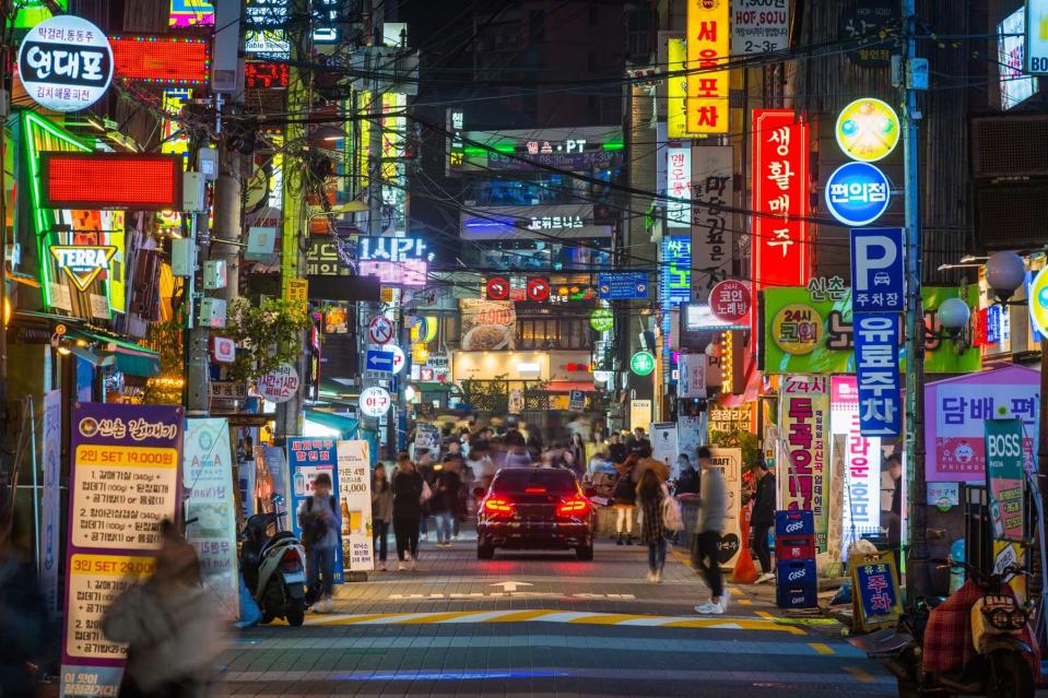 People on the crowded neon night streets of Sinchon in the heart of Seoul, South Korea’s vibrant capital city