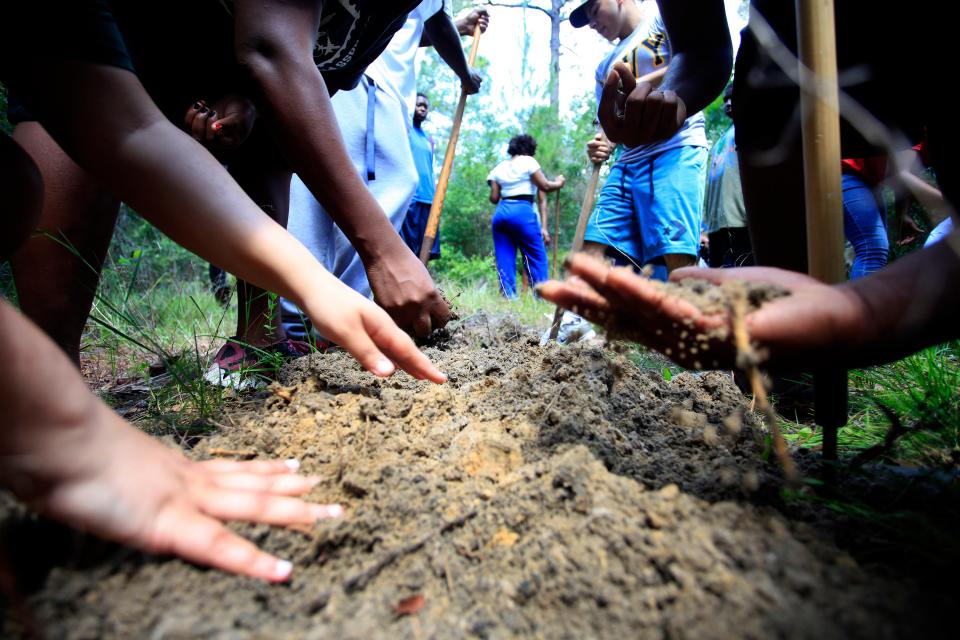 Juniors from Eastside High School take a tour of the historic site of the Rosewood Massacre with FIU professor and historian, Marvin Dunn, Wednesday, May 22, 2013 in Rosewood, Fla. Students do an archaeological dig and property maintenance at the site of the racially violent event that happened in Levy County in the 1920's. Erica Brough/Gainesville Sun