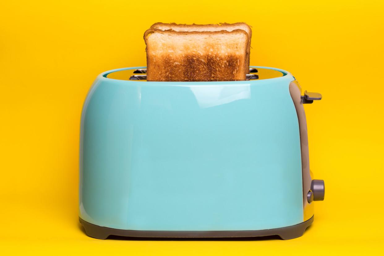 bright, fun breakfast. cyan color toaster on a yellow background