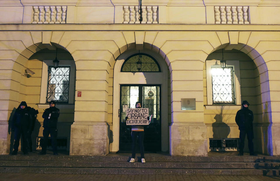 Demonstrators gather in front of the Hungarian Embassy to protest the policies of Hungarian Prime Minister Viktor Orban, in Warsaw, Poland, Wednesday, Dec. 19, 2018. The small rally came as a gesture of solidarity with Hungarians who protested for several days against recent labor law changes in Budapest Hungary. (AP Photo/Czarek Sokolowski)