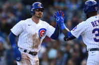Chicago Cubs' Zach McKinstry, left, celebrates with teammate Franmil Reyes, right, after scoring on an Ian Happ walk during the first inning of a baseball game against the Cincinnati Reds, Sunday, Oct. 2, 2022, in Chicago. (AP Photo/Paul Beaty)
