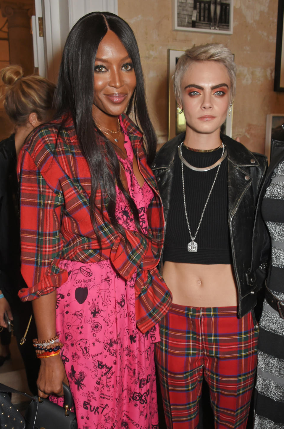 Models Naomi Campbell and Cara Delevingne wear Burberry to the brand’s September 2017 show. (Photo: Getty Images)