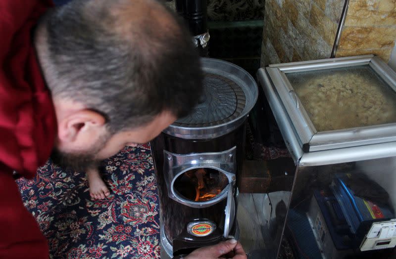 Suleiman al-Khaled, 34, uses a heater at his home in Hama