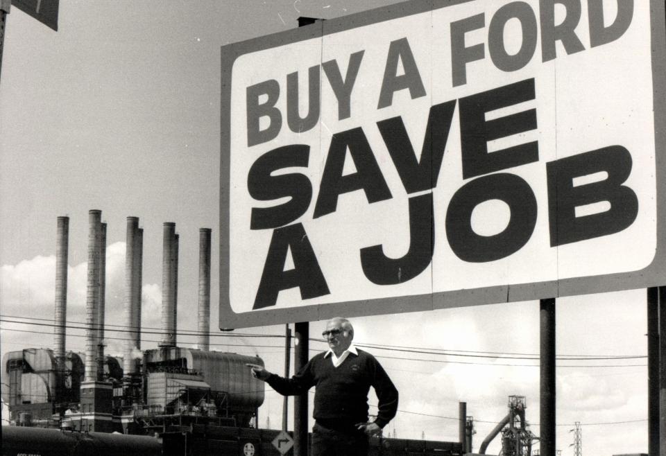 Mike Rinaldi, then-President of UAW Local 600, stands at the sign in front of his headquarters on Dix and points to the Ford Rouge Plant in 1983.