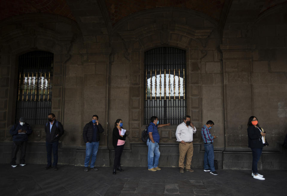 People wearing masks due to the new coronavirus pandemic wait for City Hall to open in Mexico City, Monday, June 1, 2020. While the federal government’s nationwide social distancing rule formally ended Monday, it is urging people in so-called “red” zones to maintain most of those measures — and so many people are falling ill and dying each day that those zones cover nearly the whole country. (AP Photo/Fernando Llano)