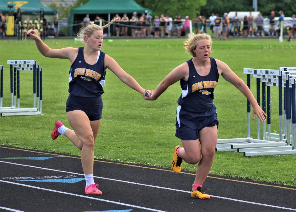 Erie Mason's Mikaela Graves and Jenna Wright exchange the baton during the 800 relay in the Division 3 Regional Saturday, May 21, 2022 at Whiteford.