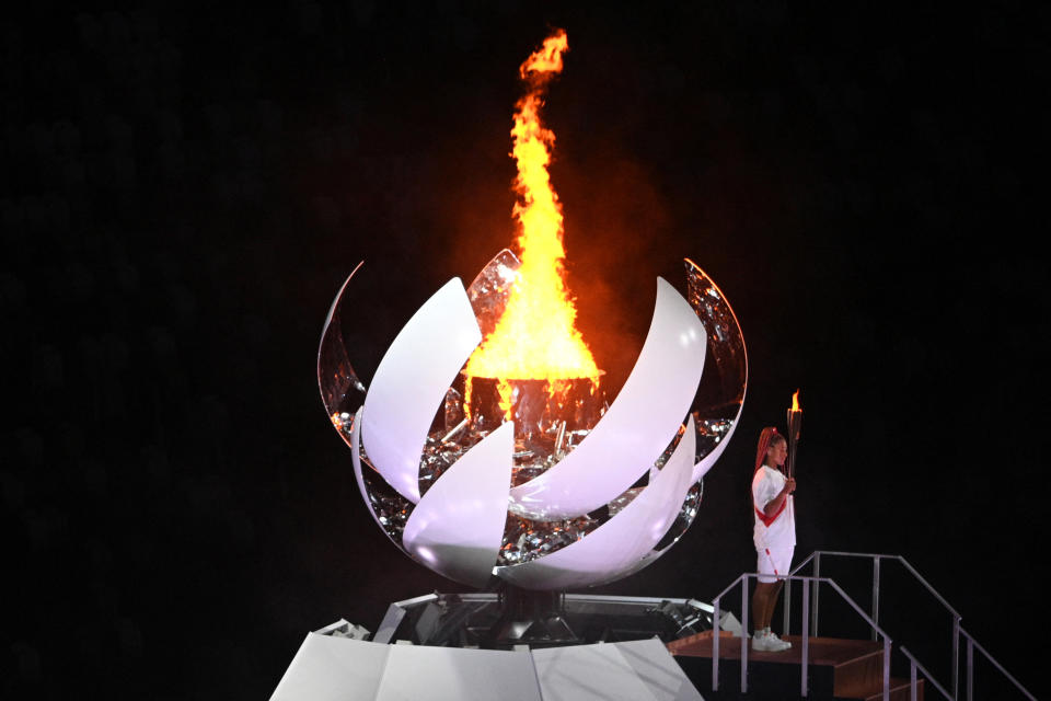 <p>Japan's tennis player Naomi Osaka holds the Olympic torch after lighting the Olympic flame in the Olympic Stadium during the opening ceremony of the Tokyo 2020 Olympic Games, in Tokyo, on July 23, 2021. (Photo by Martin BUREAU / AFP) (Photo by MARTIN BUREAU/AFP via Getty Images)</p> 