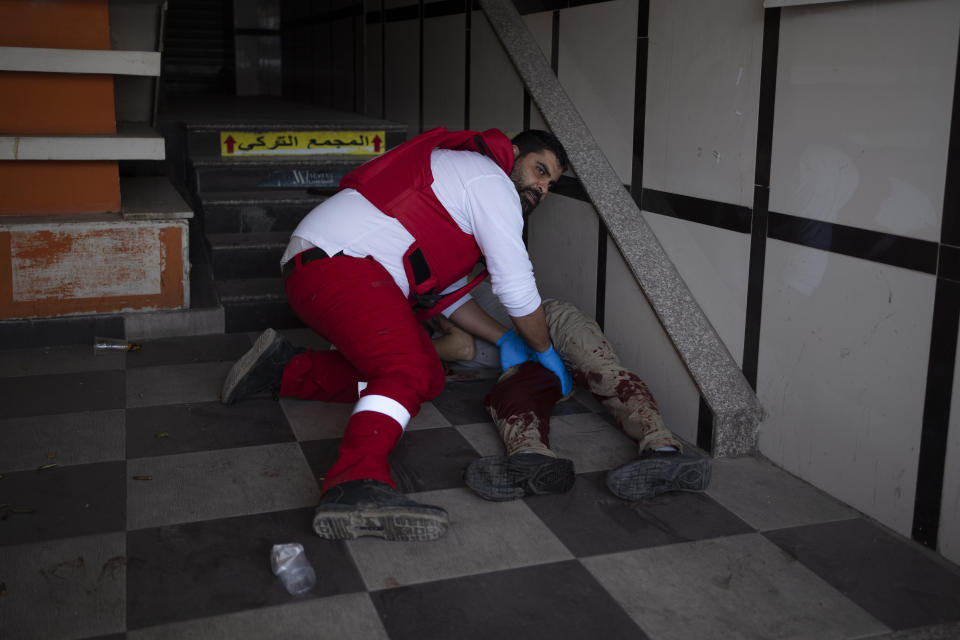 A paramedic holds the leg of an injured Palestinian during clashes with Israeli forces in the West Bank city of Jenin, Wednesday, May 22, 2024. (AP Photo/Leo Correa)