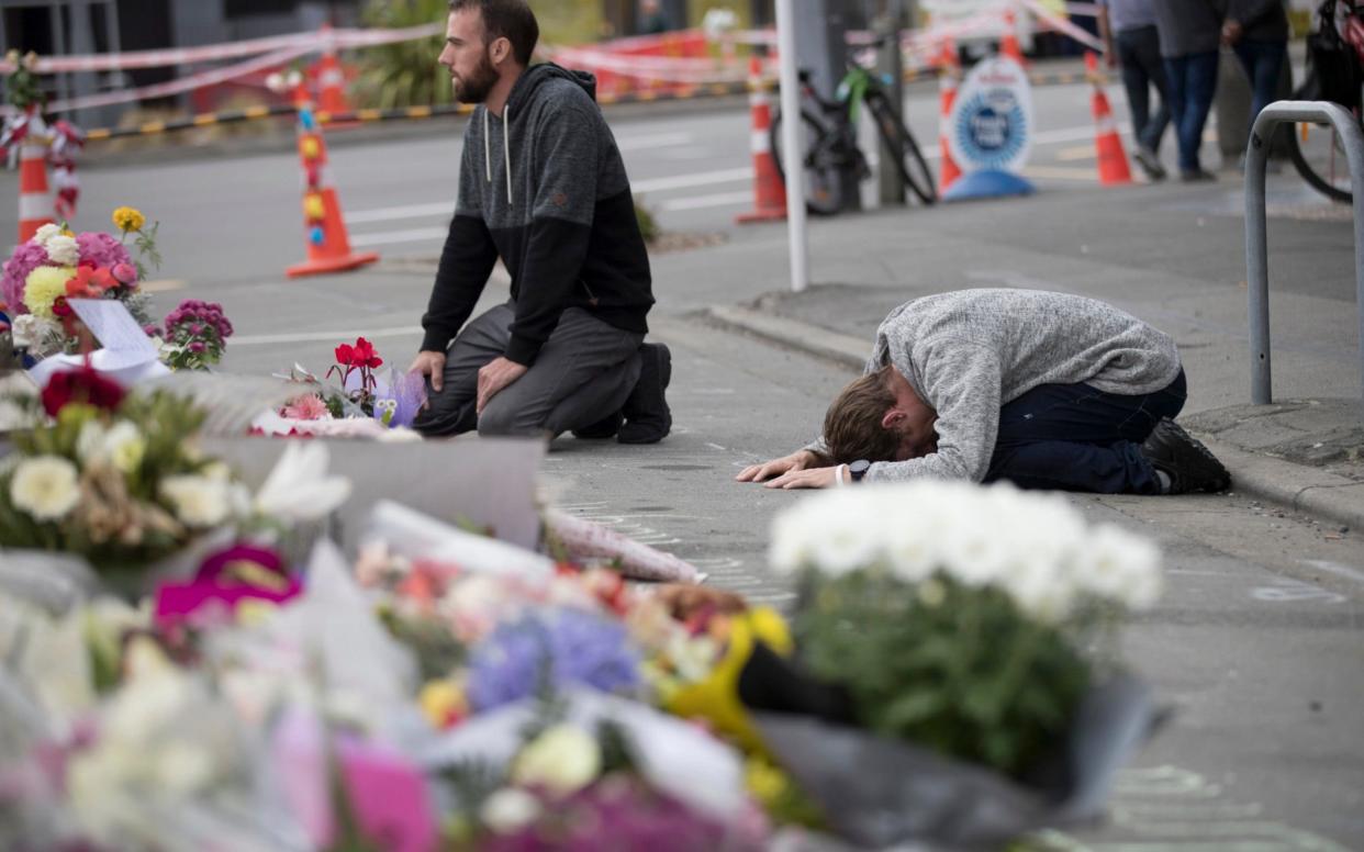 Mourners pray near the Linwood mosque in Christchurch, New Zealand - AP