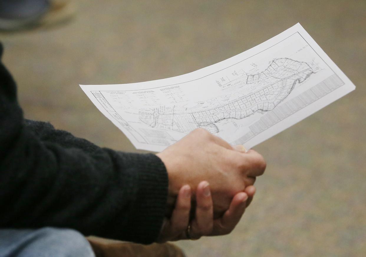 A member of the public holds a copy of subdivision plans Wednesday during a New Franklin Planning & Zoning Commission meeting.