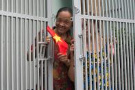 A woman waves a flag as US President Barack Obama's motorcade passes by in Vietnam's Ho Chi Minh City on May 24, 2016