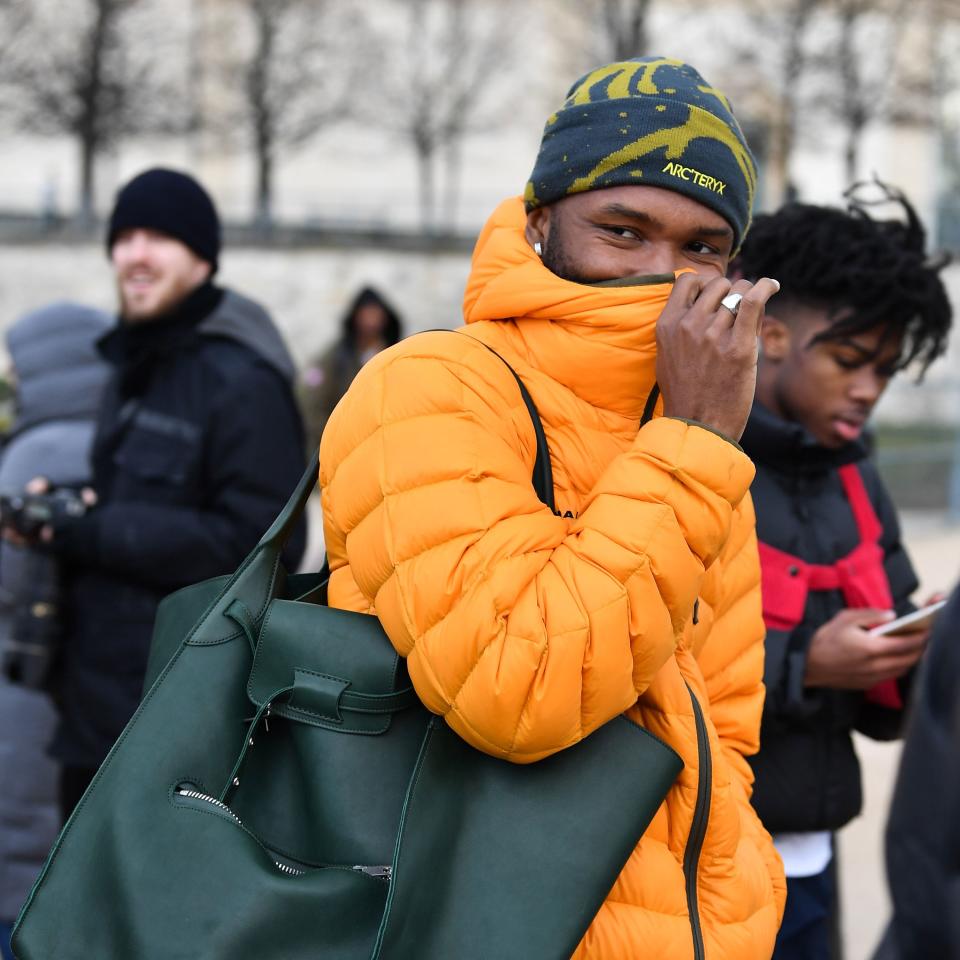 He paired the oversize bag with a vibrant puffer and a printed beanie.
