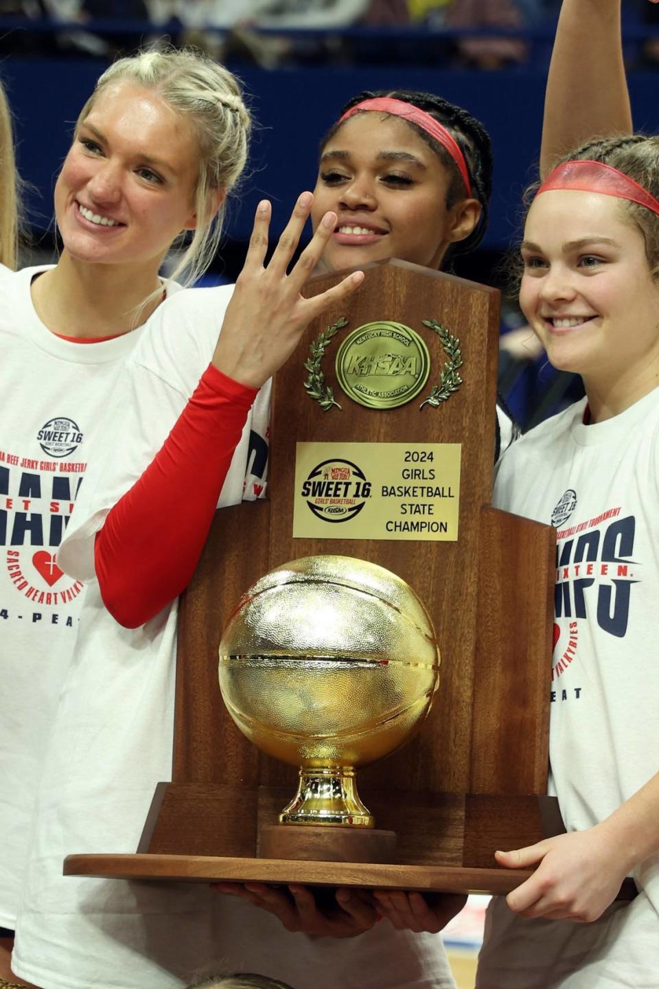 Sacred Heart’s ZaKiyah Johnson (11) holds up four fingers after helping the Valkyries to their fourth consecutive state championship last month. James Crisp