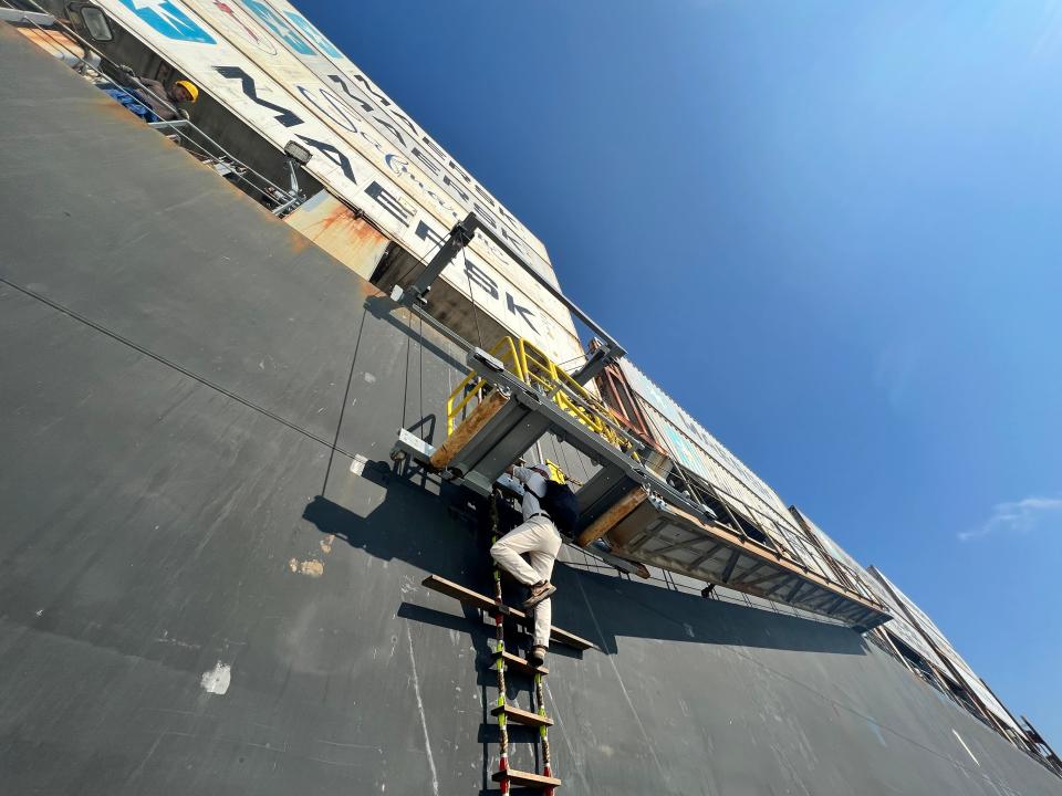 Cape Fear River Pilot Scott Aldridge climbs from the rope ladder to a gangplank to board the San Americo on Wednesday, July 12, 2023.