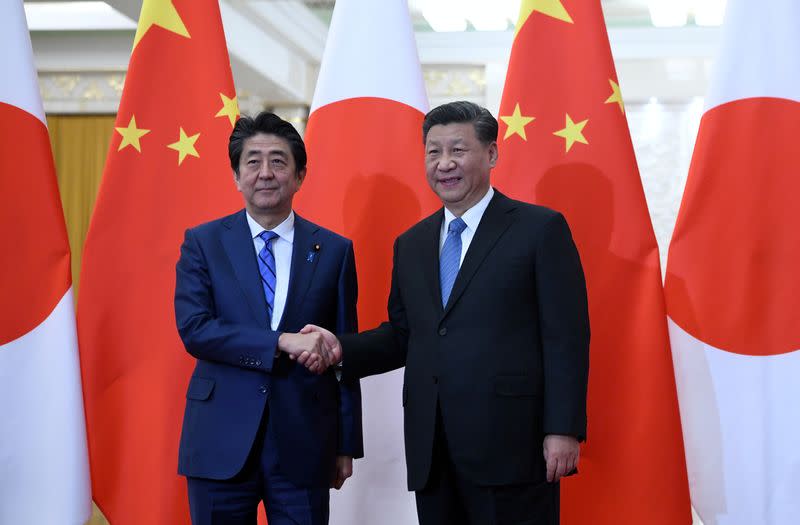 Japan's Prime Minister Shinzo Abe shakes hands with China's President Xi Jinping at the Great Hall of the People in Beijing
