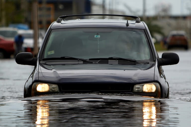 A car drives though a flooded street in the aftermath of Hurricane Maria in San Juan, Puerto Rico