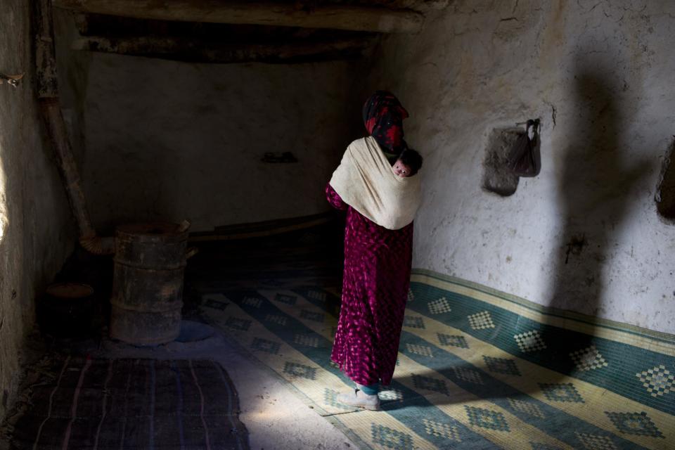 Bari Moumouch, una madre bereber de 20 años, camina con su hijo recién nacido en su espalda en el pueblo de Ait Sghir.